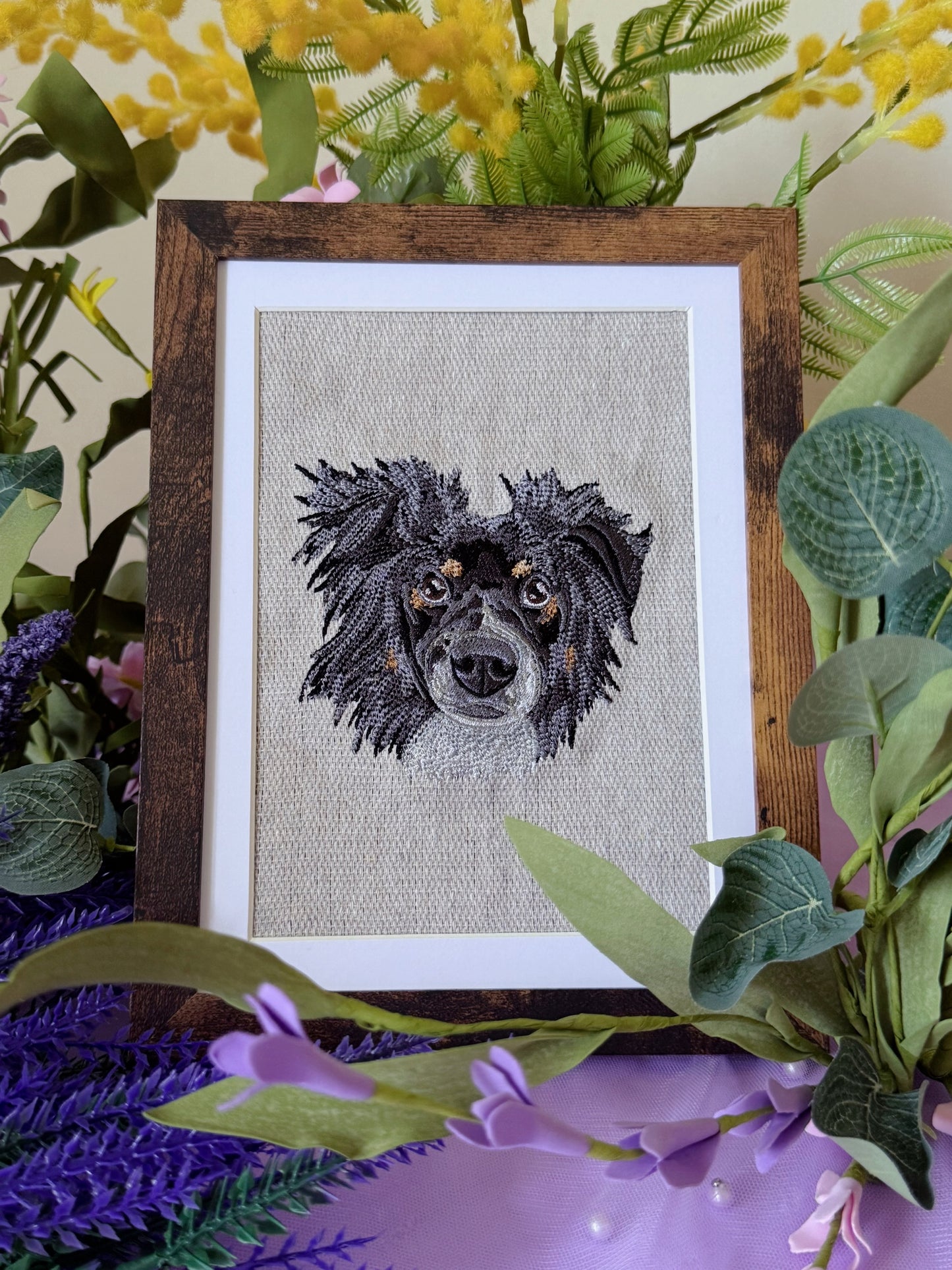 Framed embroidered portrait of a dog surrounded by flowers and leaves