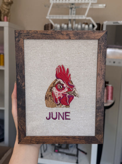 Framed embroidered chicken named June in an artistic studio setting
