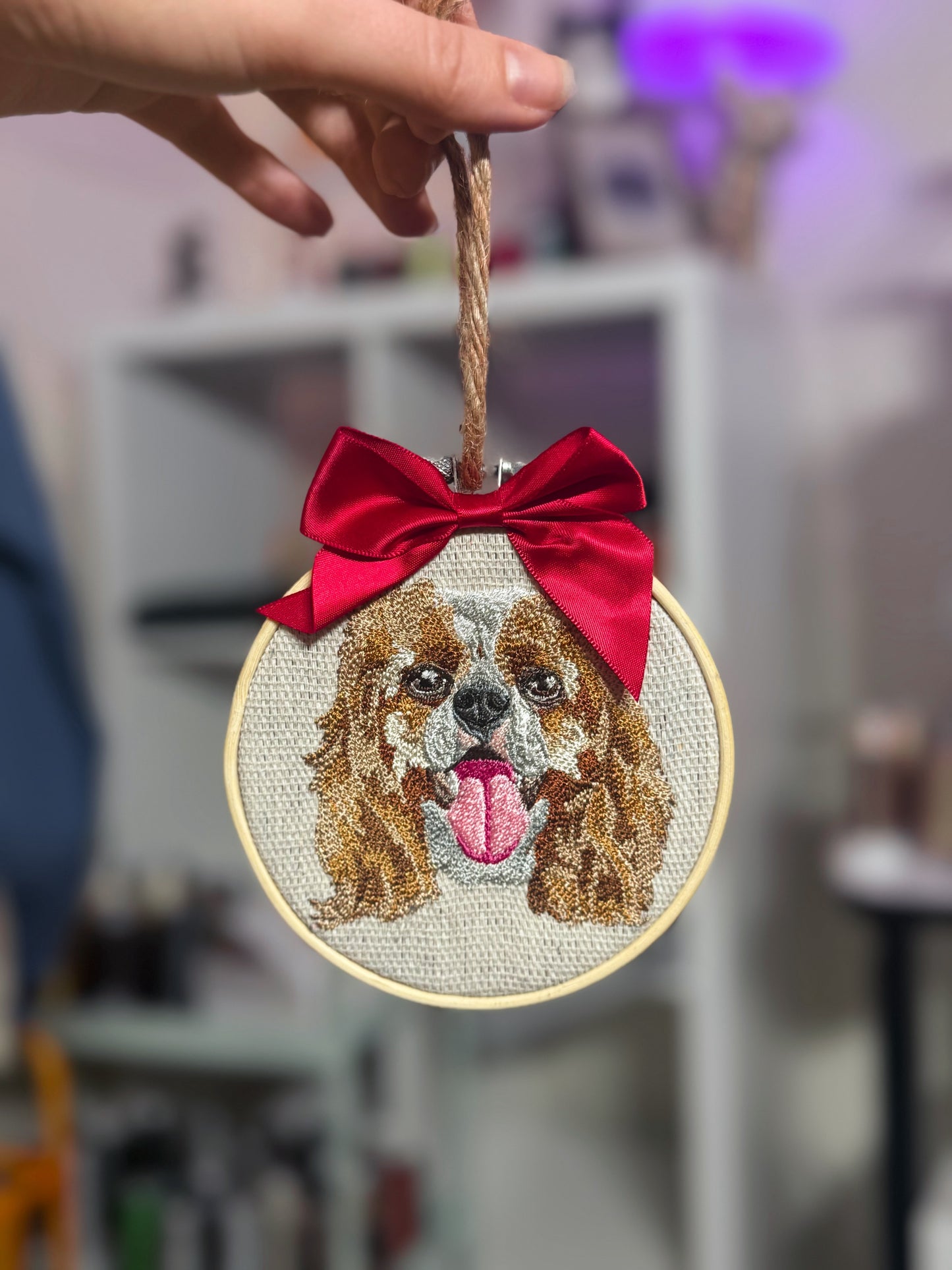 Embroidered dog portrait with a red bow on a blurred background