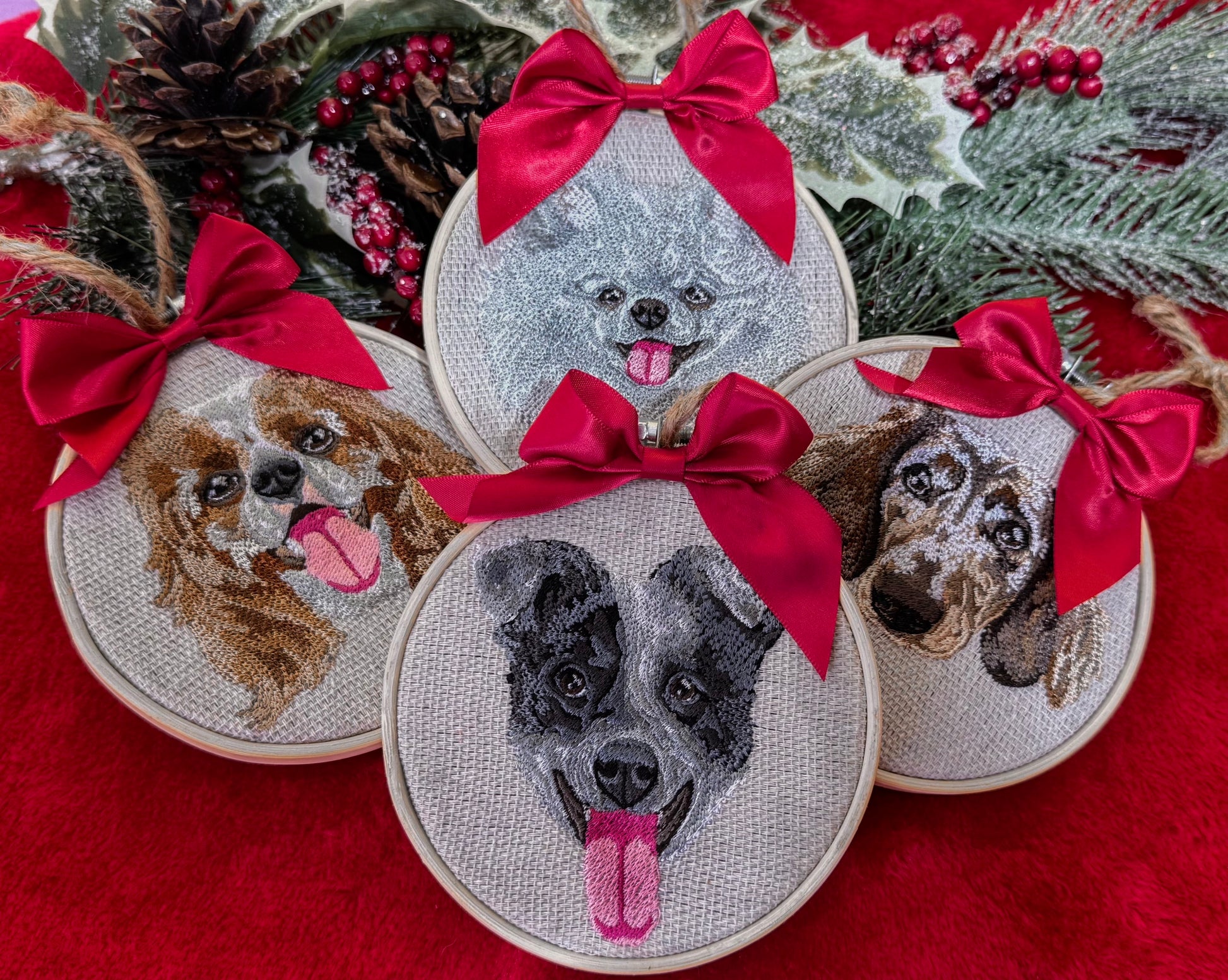 Custom embroidered dog portraits with red bows on a red fabric background