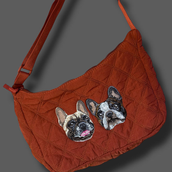 Red handbag with dog illustrations on a gray background