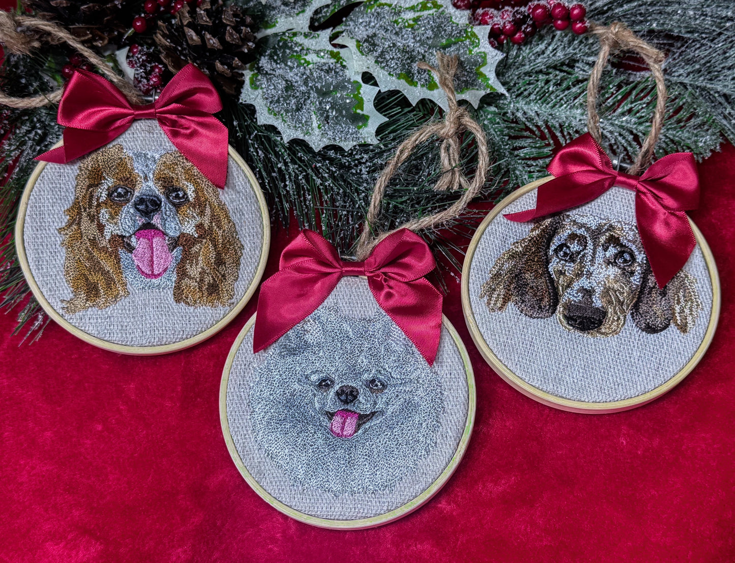 Embroidered dog portraits with red bows on a red fabric background