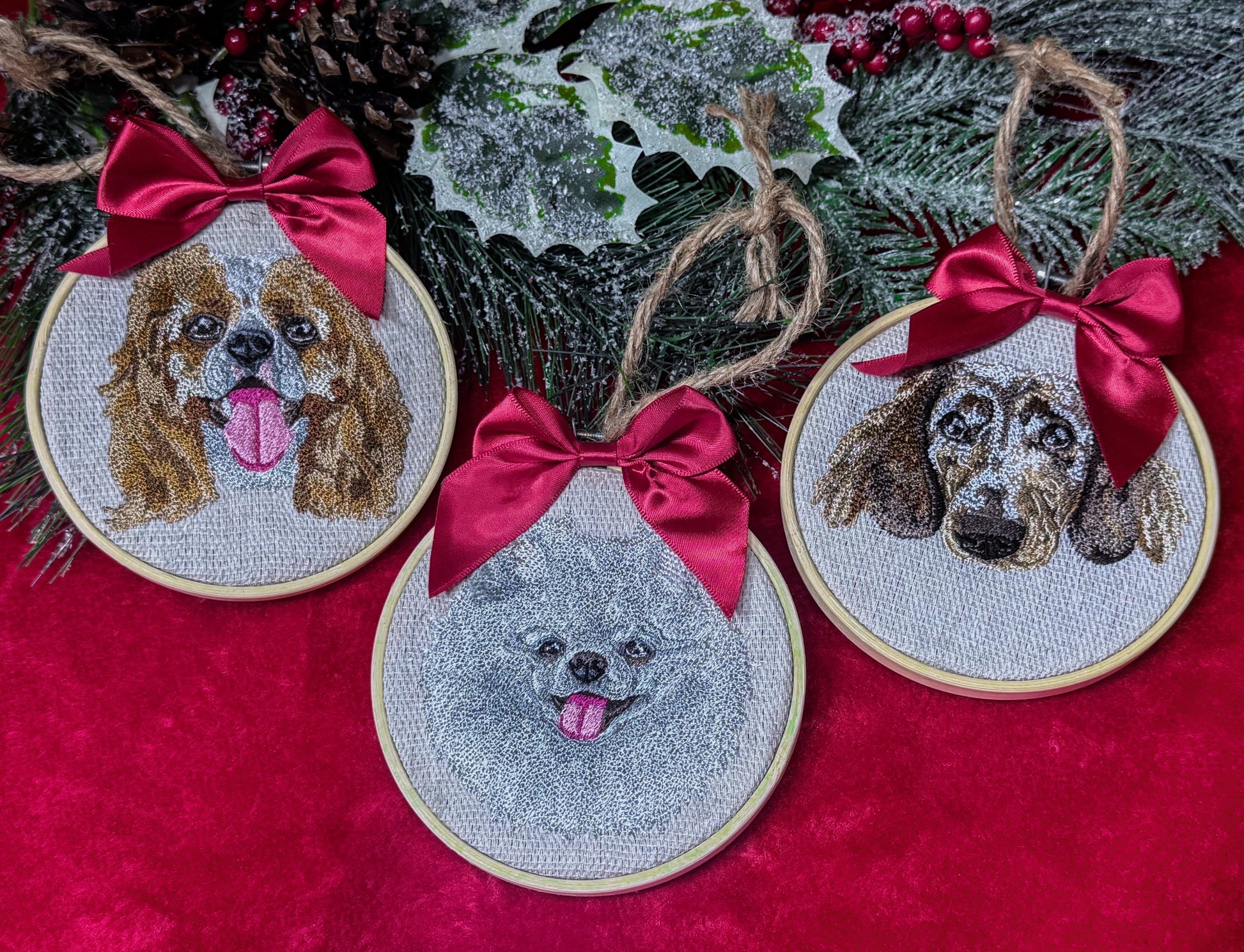 Embroidered dog portraits with red bows on a red fabric background